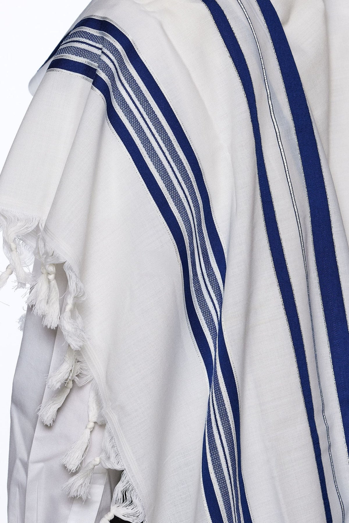 Modim classic wool tallit draped over the shoulders, showing the royal blue stripes
